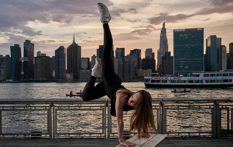 Ashley McQueen dancing in front of a city skyline