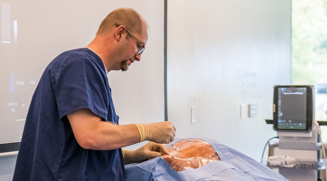 Nursing student practicing in simulated lab.