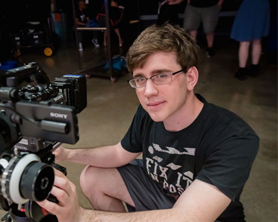 Aaron Kayser working with a film camera.