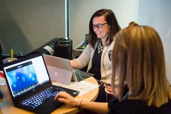 Two students working together on laptops